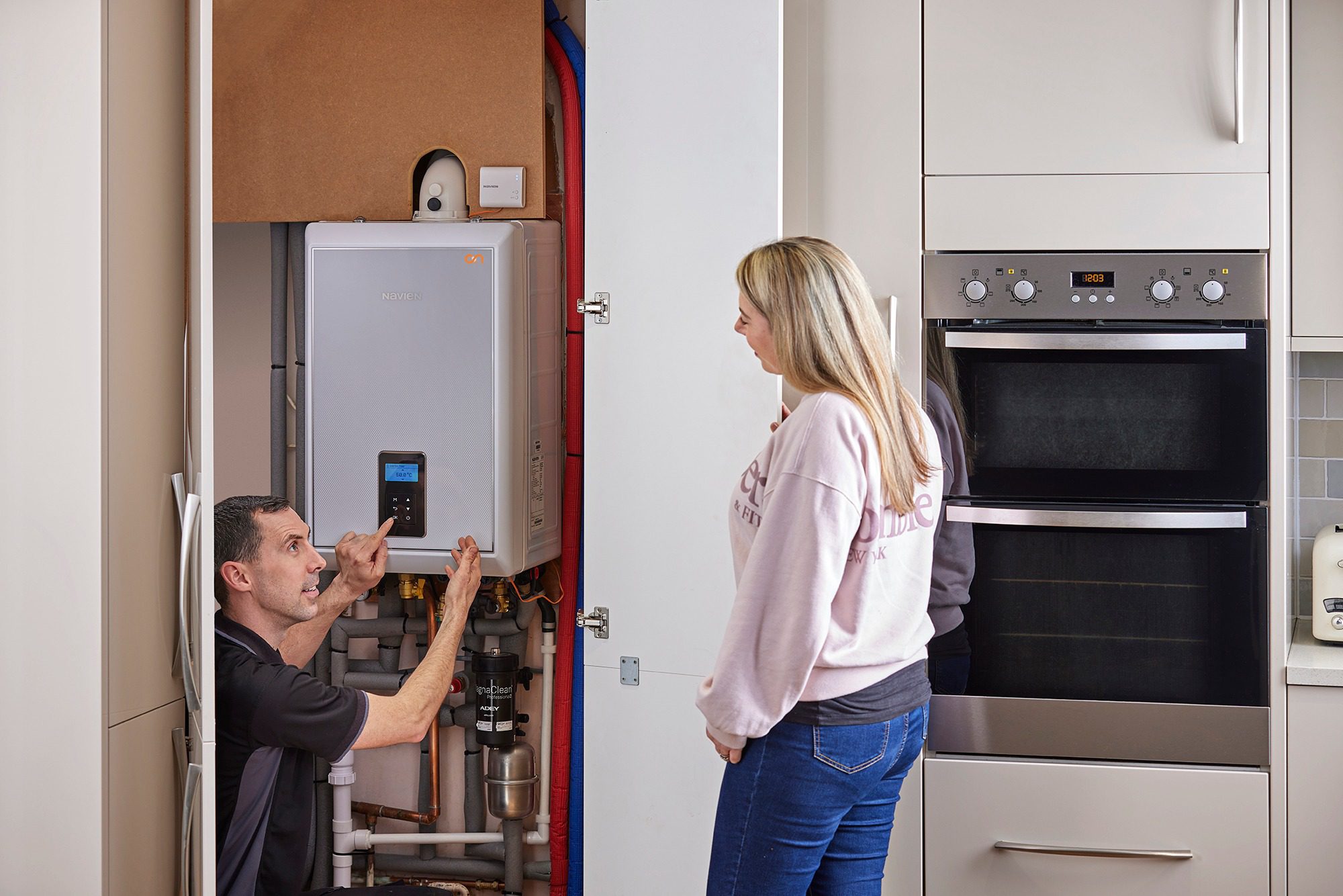 343100223_534837005395852_6463236354047573885_n Picture of engineer showing customer boiler